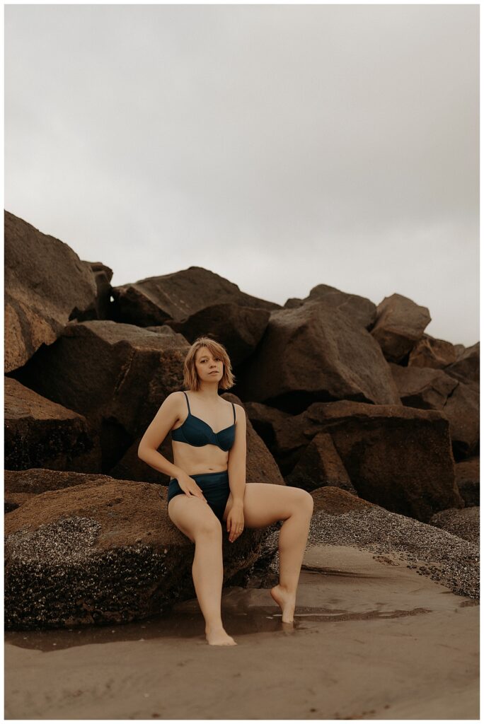 Person sits on beachside rocks for Minneapolis Boudoir Photographer