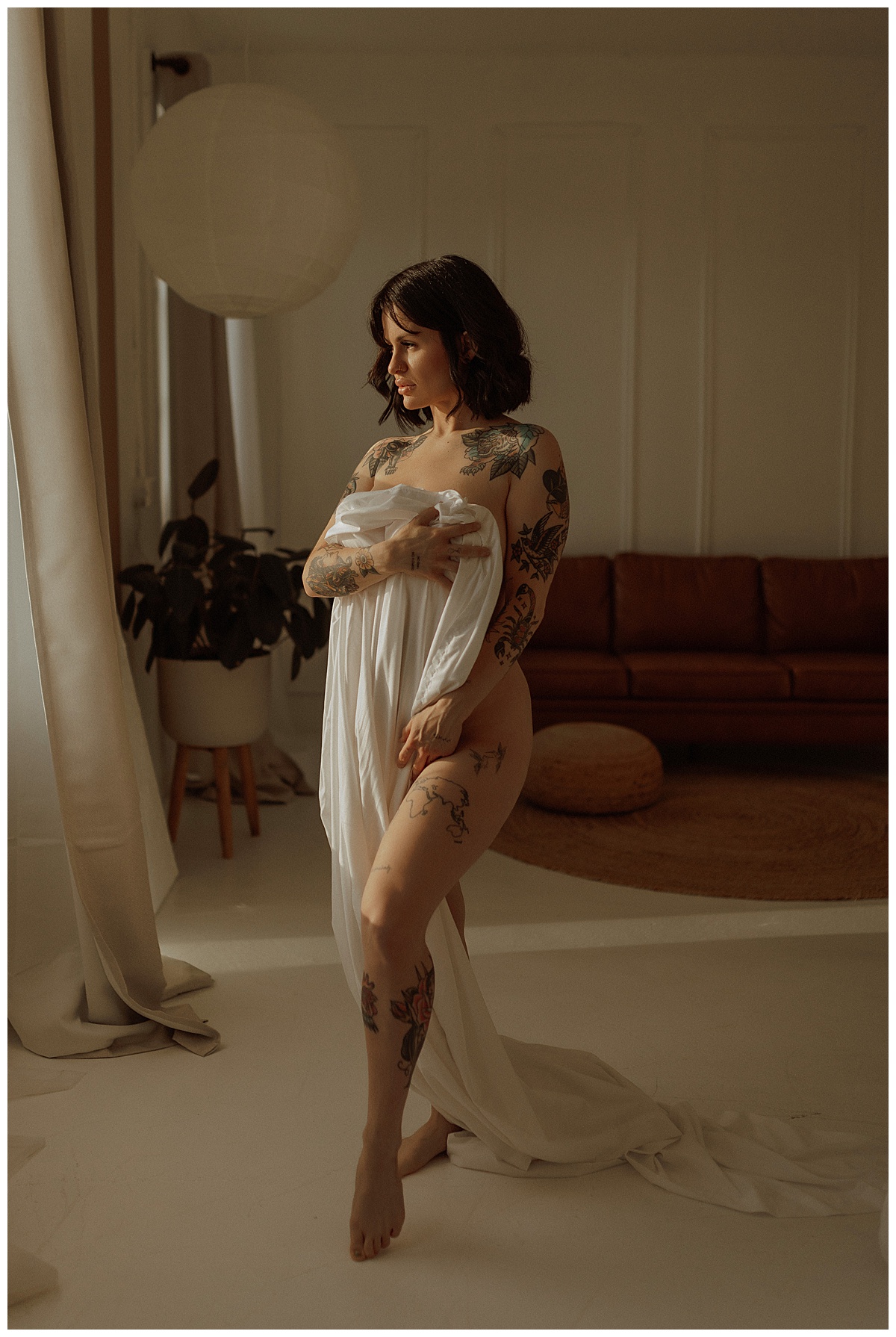 Woman covers body with sheet followingWhat To Expect During Your Boudoir Session