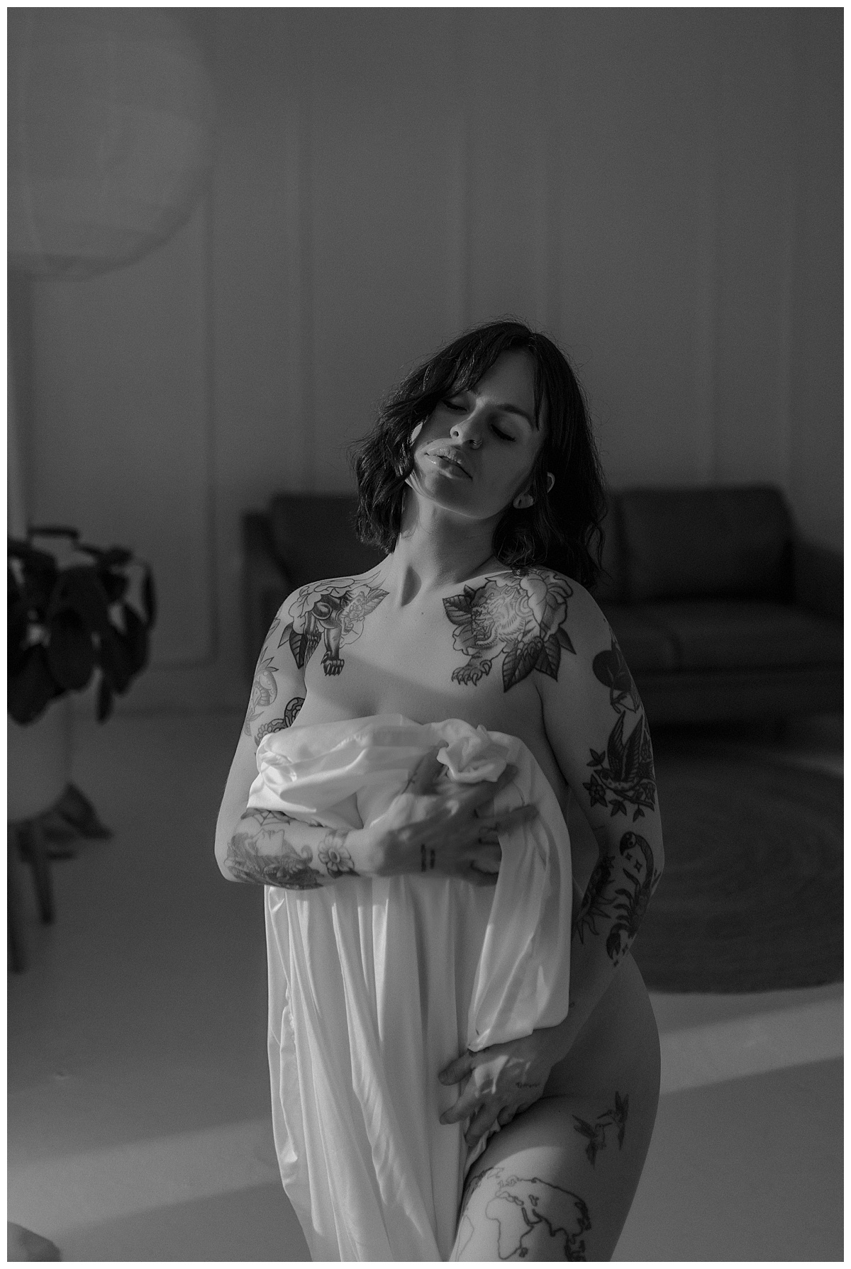 Woman covers her chest with white sheet following What To Expect During Your Boudoir Session