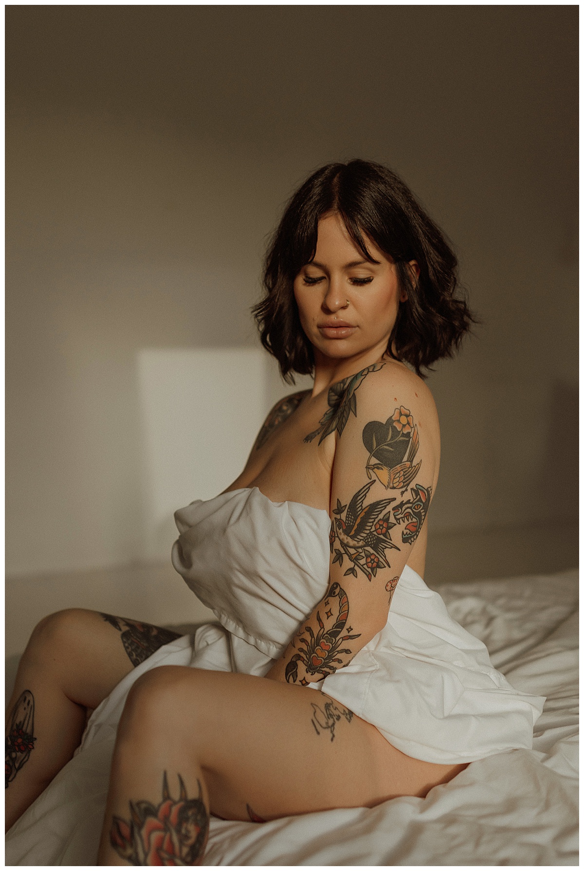 Person covers her chest with white sheet following What To Expect During Your Boudoir Session