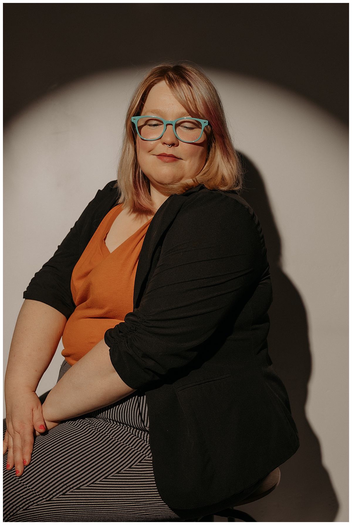 Woman sits on a stool following tips for Preparing for Your Creative Headshot Session