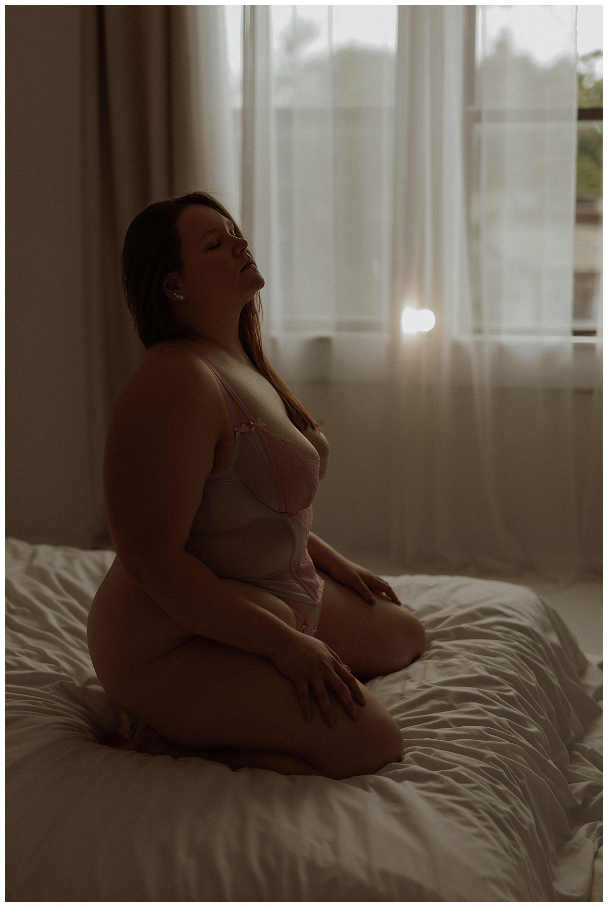 Woman kneels in the bed wearing lingerie for Minneapolis Boudoir Photographer