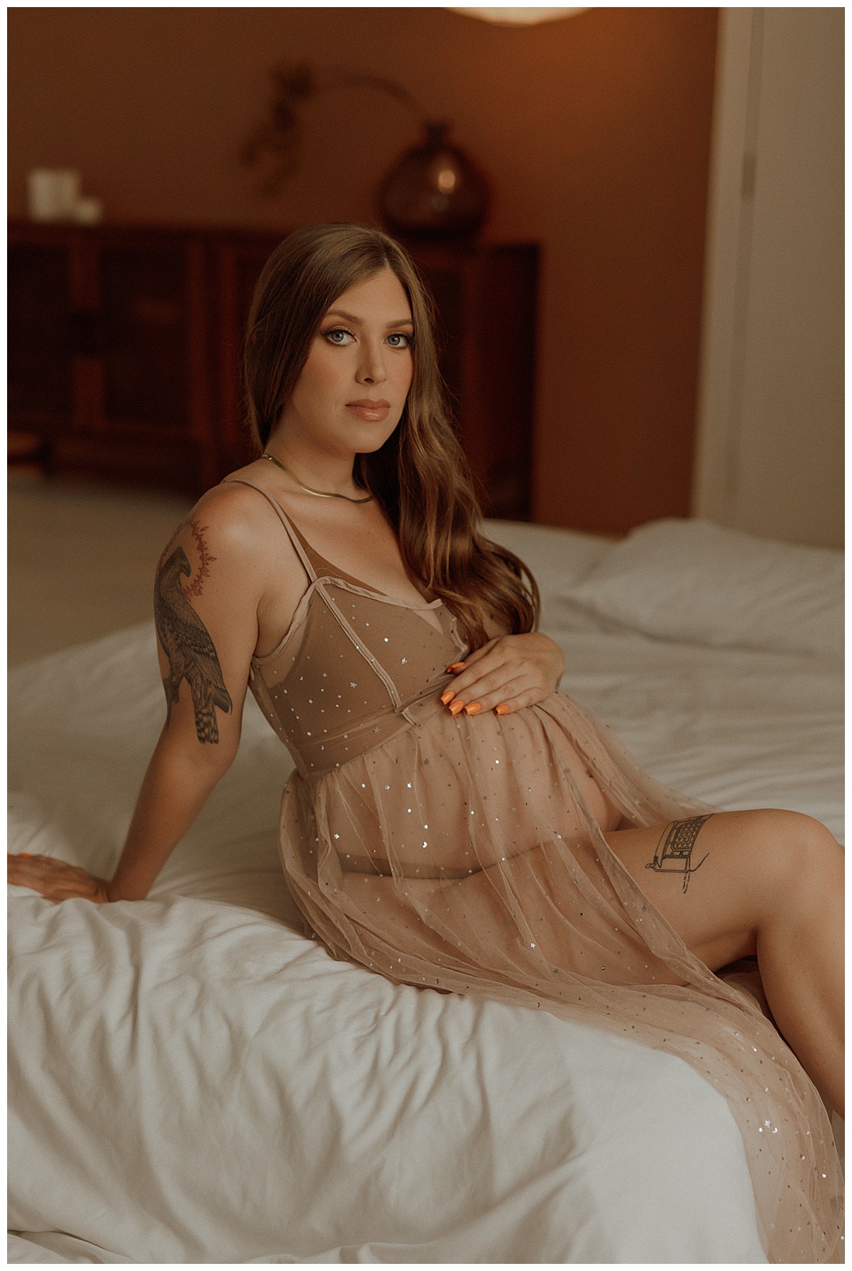 Woman holds her baby bump showing What to Wear for Your Maternity Boudoir Photos