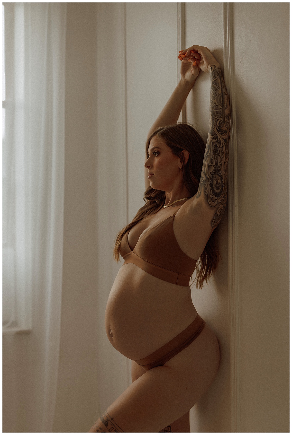 Female wears brown lingerie set showing What to Wear for Your Maternity Boudoir Photos