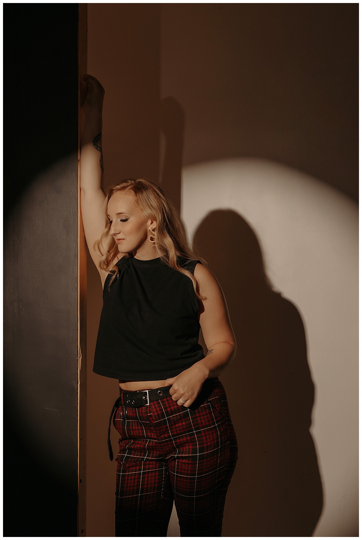 Woman leans against a wall during her Creative Headshots