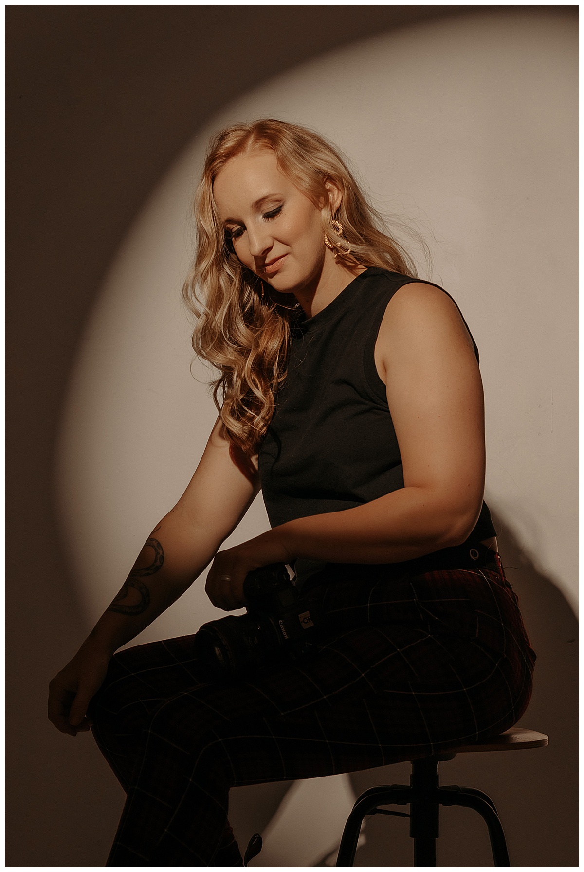 Female sits on a stool and looks down for Minneapolis Boudoir Photographer