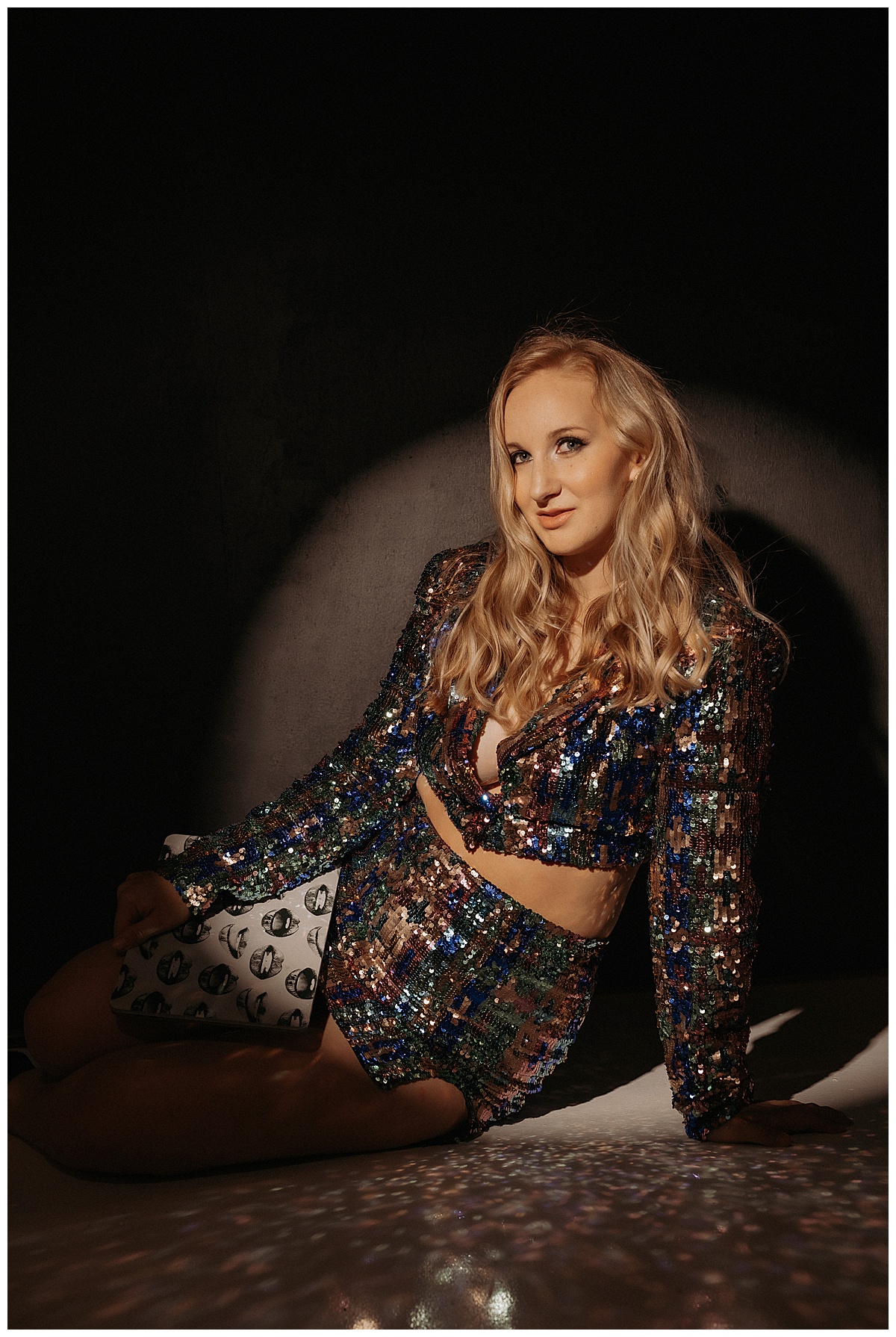 Woman wears sparkly suit and leans down fpr Minneapolis Boudoir Photographer