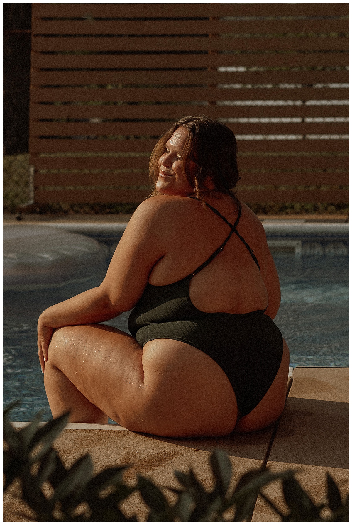 Woman wears black bathing suit and smile big by Minneapolis Boudoir Photographer