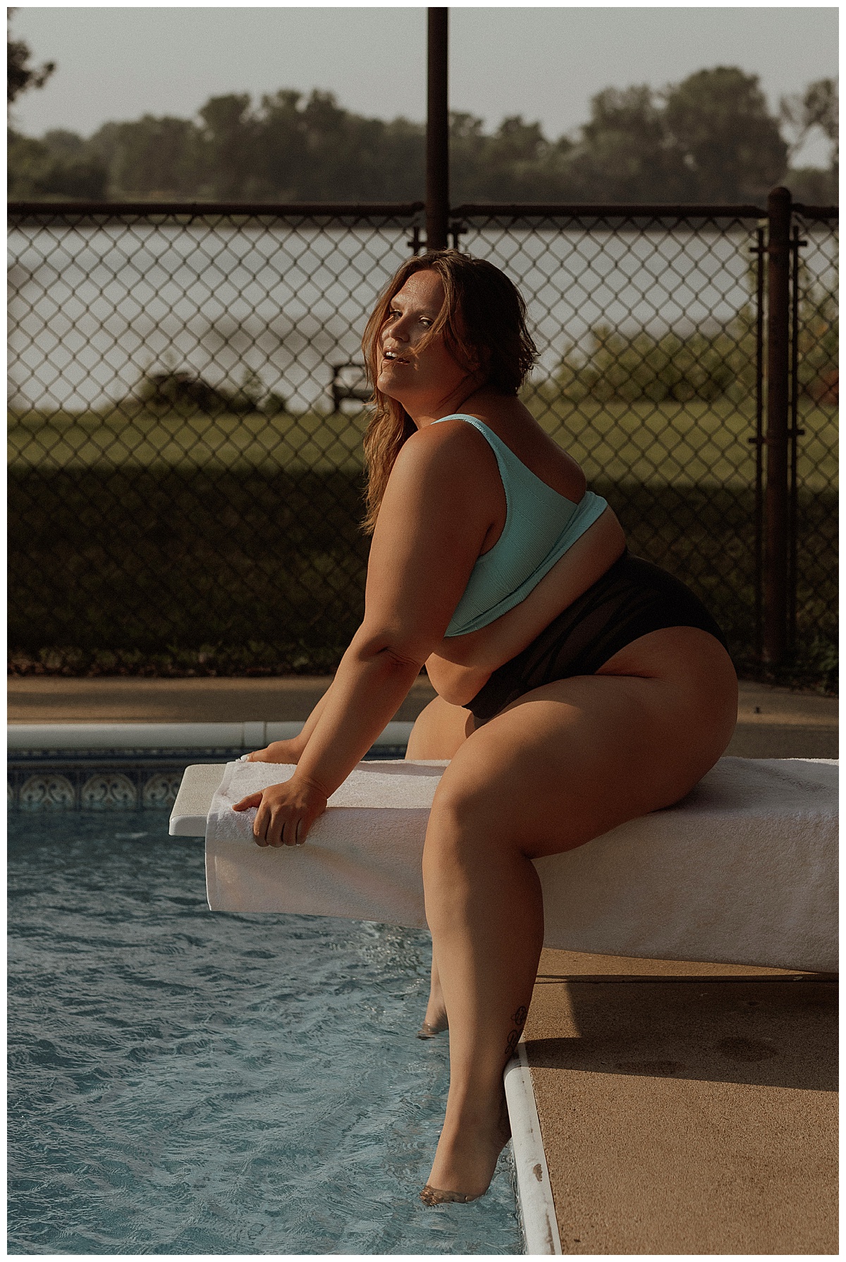 Adult sits on diving board after following What to Wear for Your Pool Session 