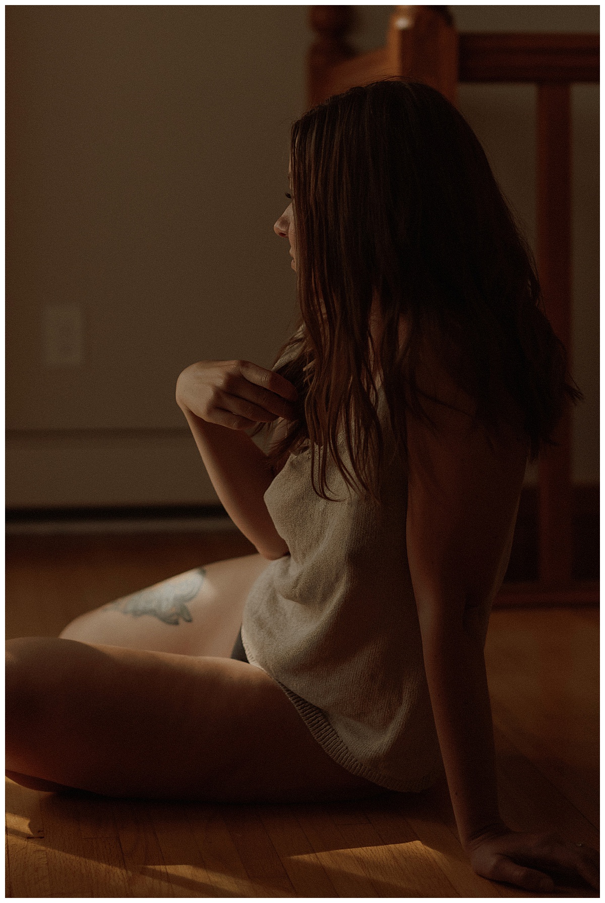 Adult wears comfy tee and holds her hair by Minneapolis Boudoir Photographer