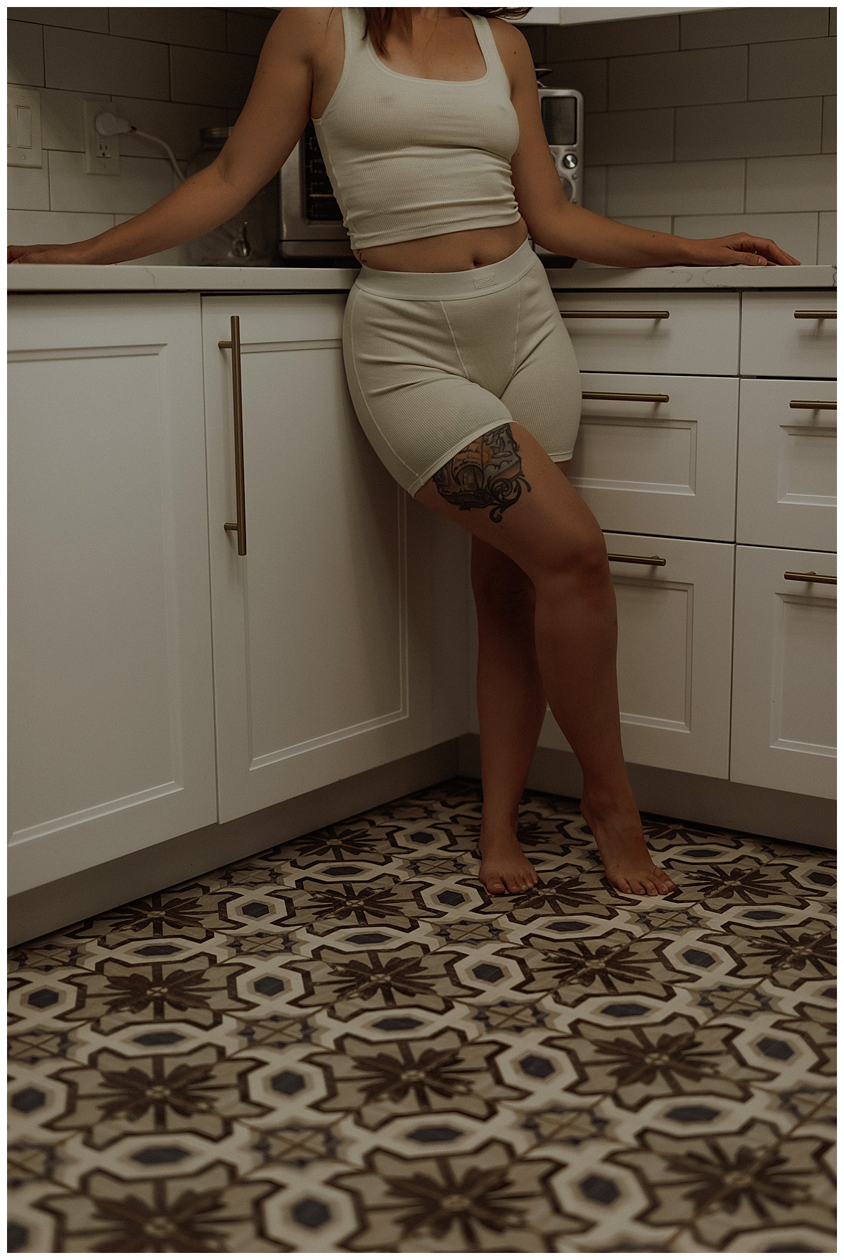 Adult leans against the counter wearing cozy lingerie by Mary Castillo Photography