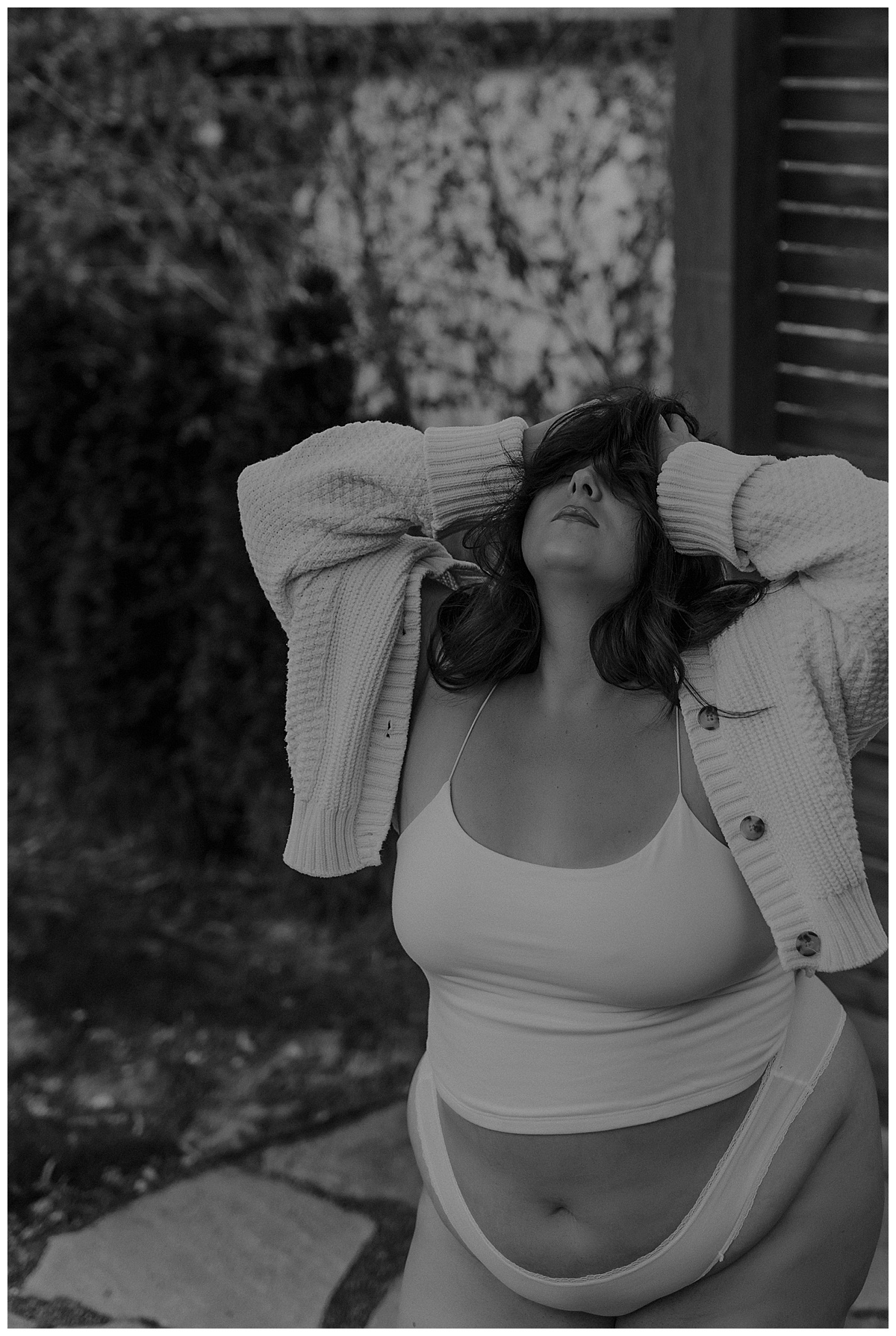 Adult covers her eyes while wearing a white cardigan set for Minneapolis Boudoir Photographer