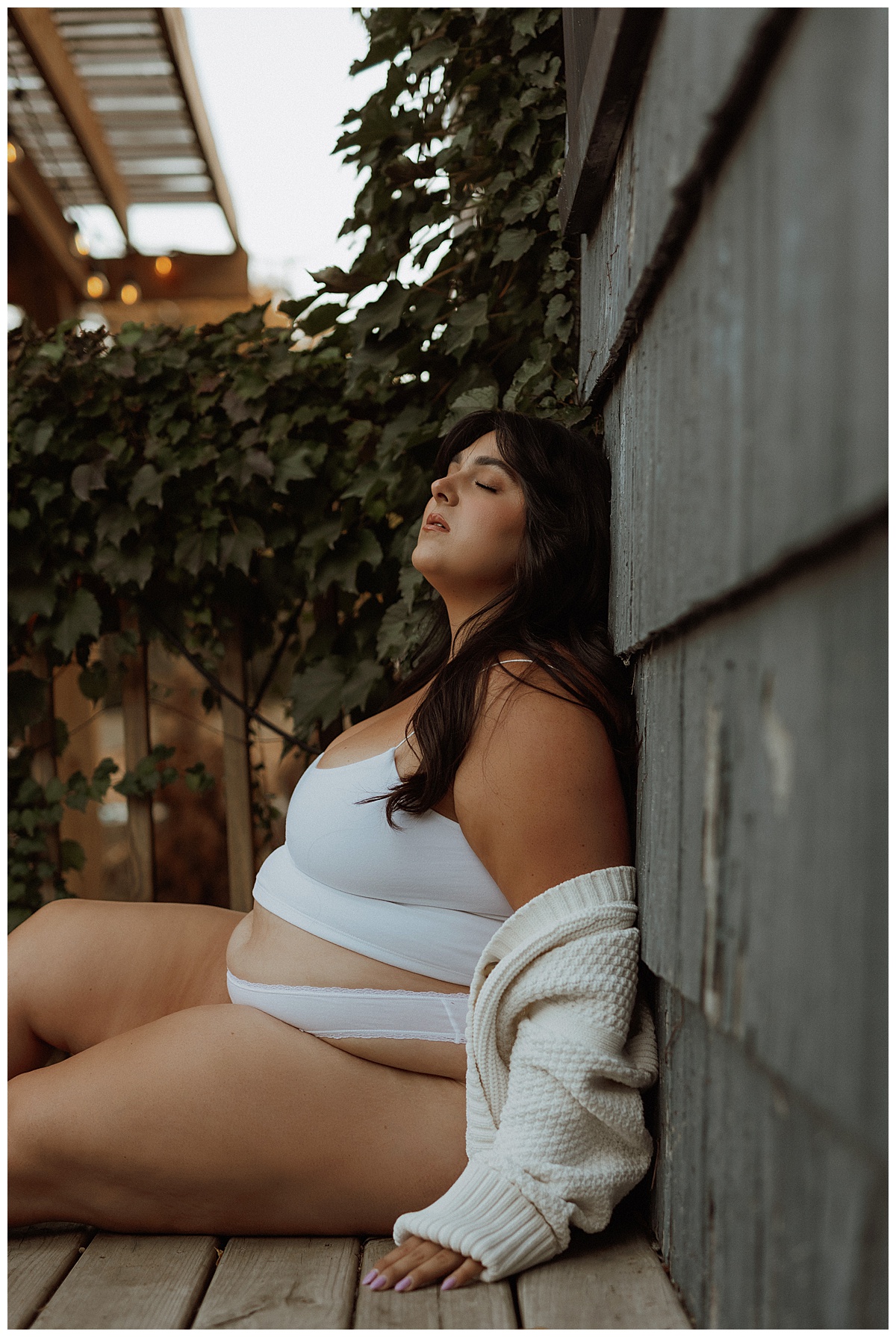 Adult lays on the side of house for Minneapolis Boudoir Photographer