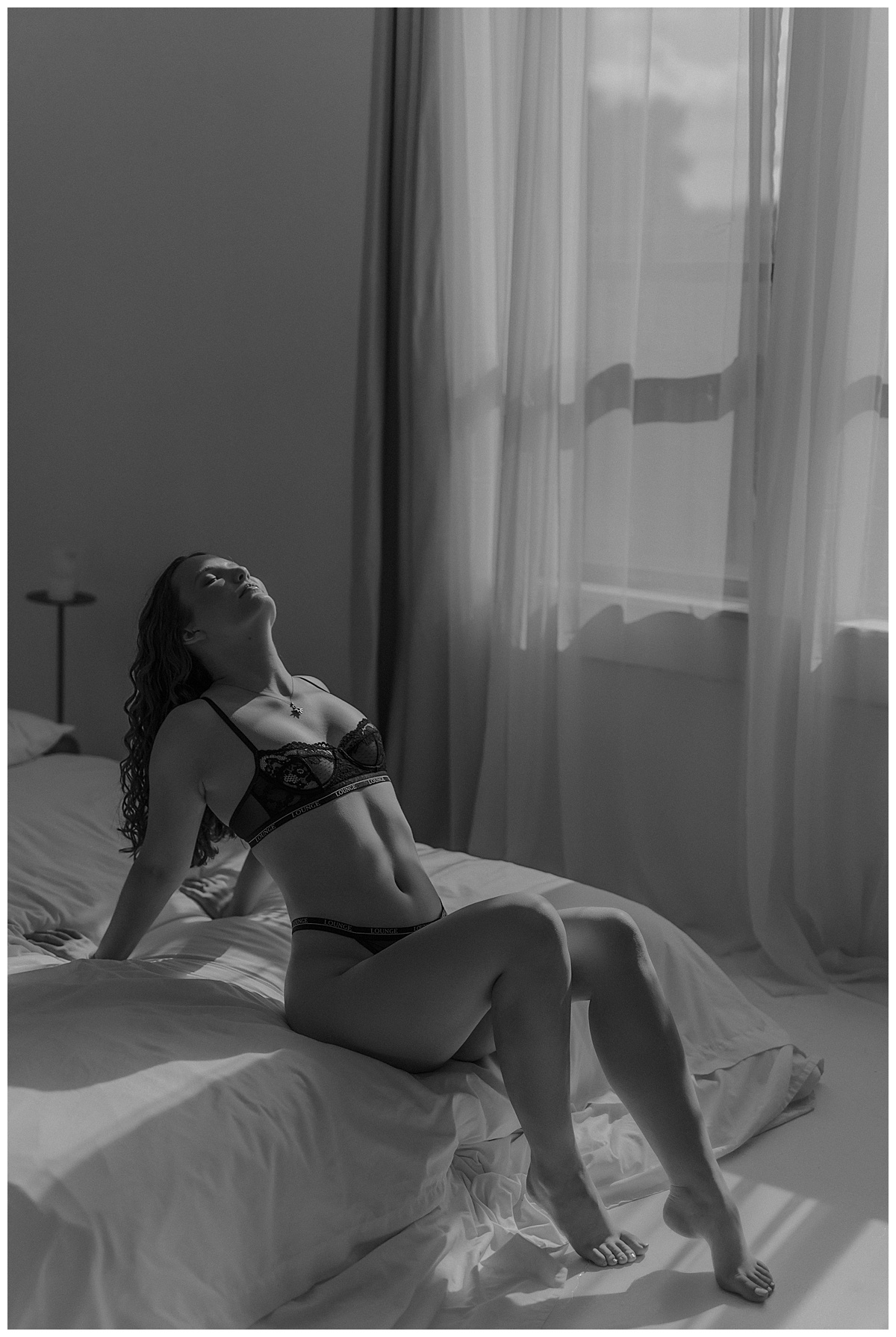 Adult leans on the edge of the bed for Mary Castillo Photography