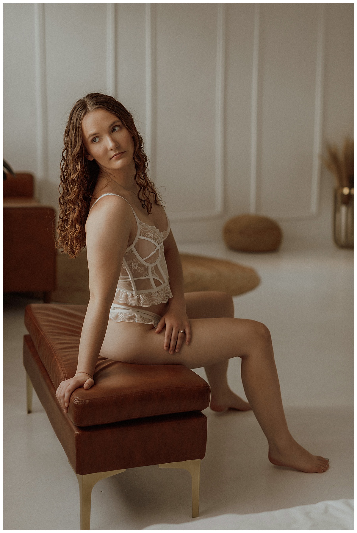 Adult wears white lingerie while sitting on a chair for Mary Castillo Photography