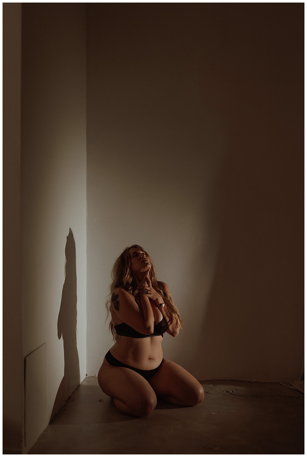 Woman kneels down in the corner for Minneapolis Boudoir Photographer