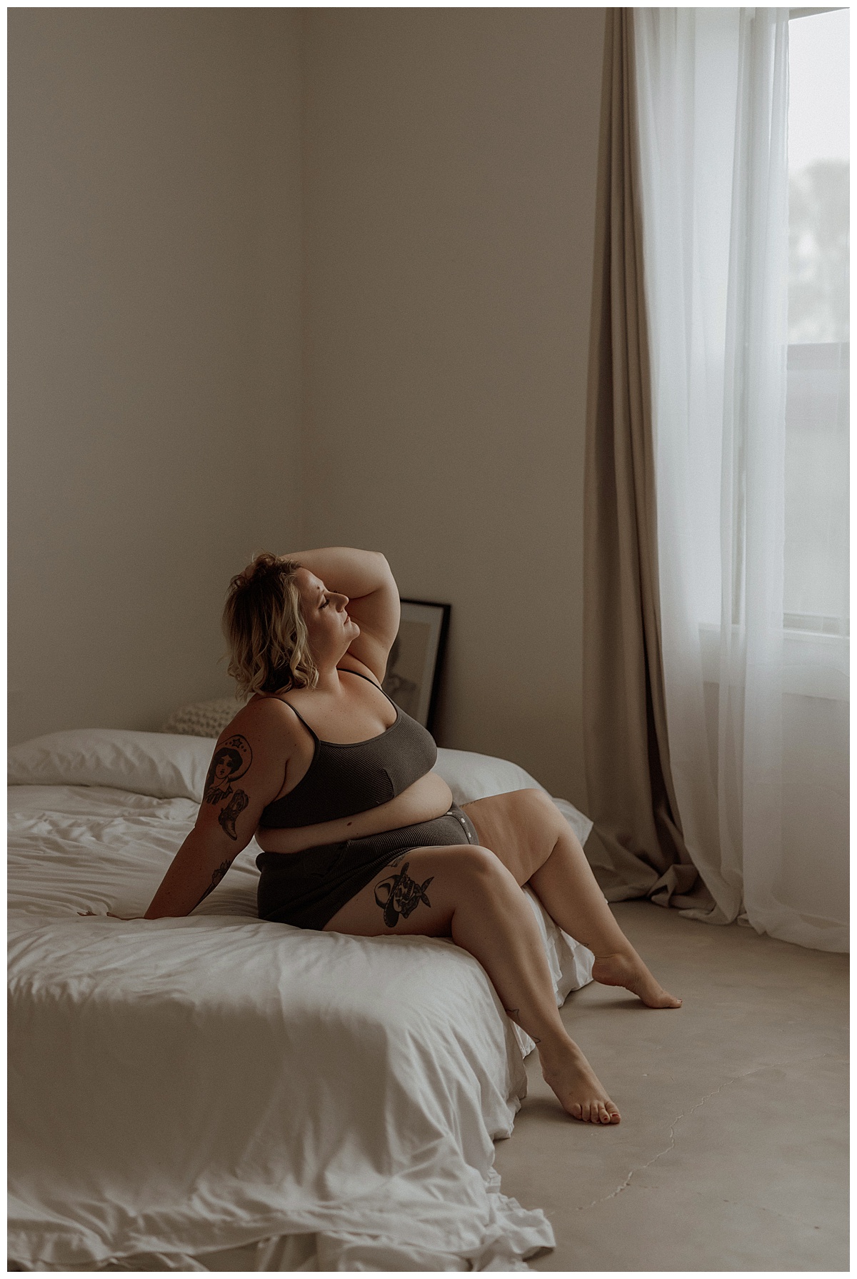 Woman wears black lingerie while sitting on the bed for Mary Castillo Photography