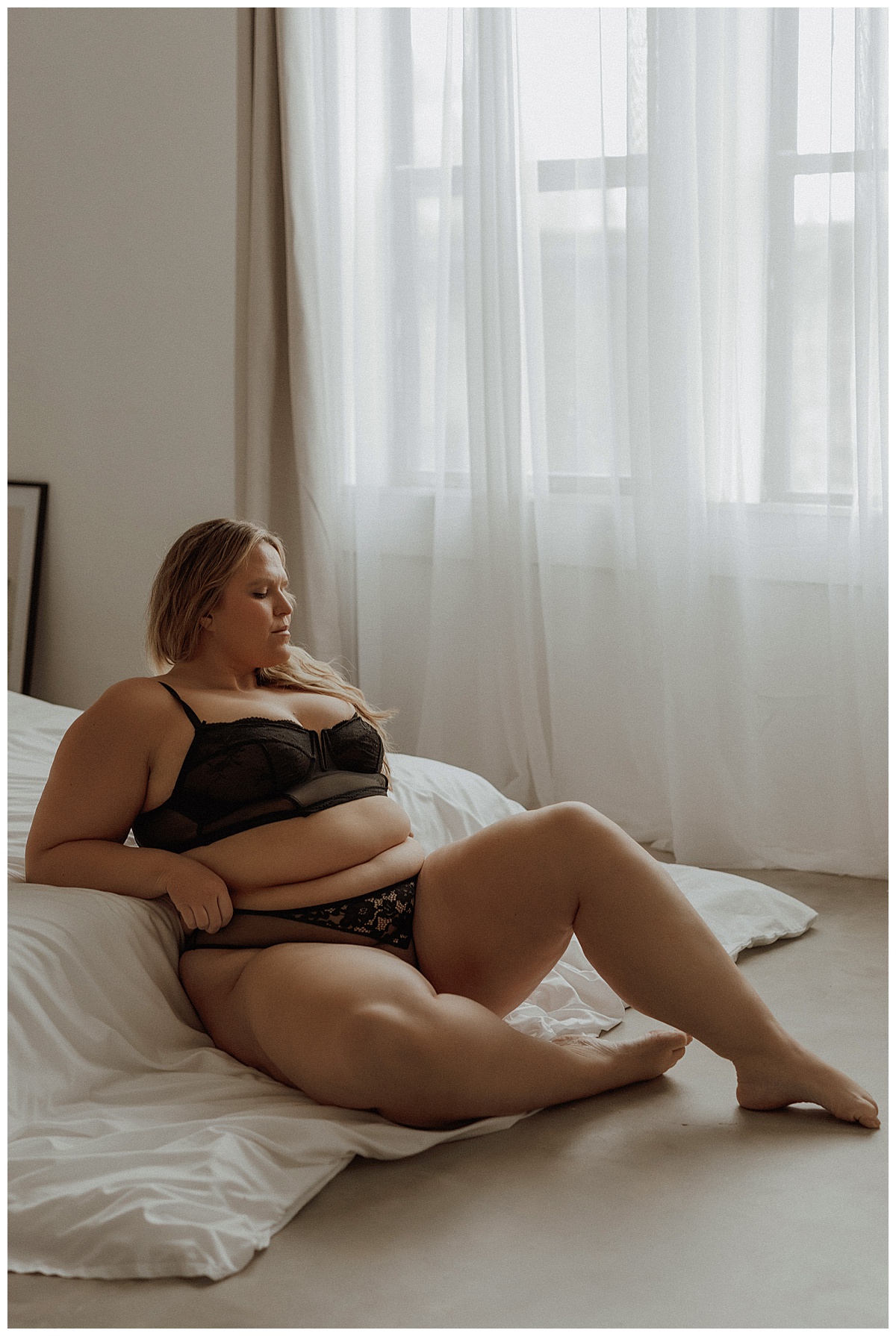 A person sits against the bed for Minneapolis Boudoir Photographer