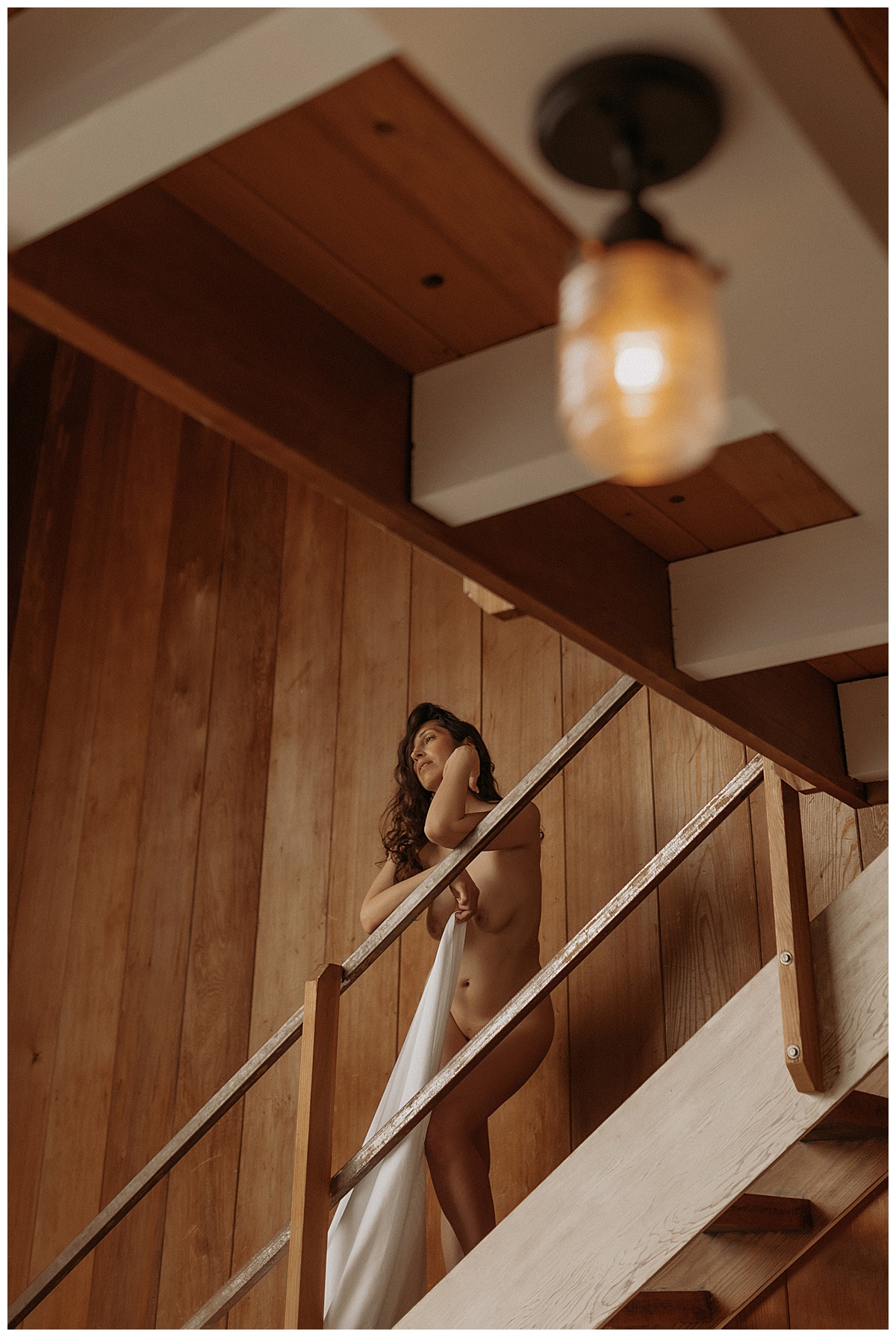 Adult stands on a staircase holding a white sheet during the LA FEYRE Workshop 