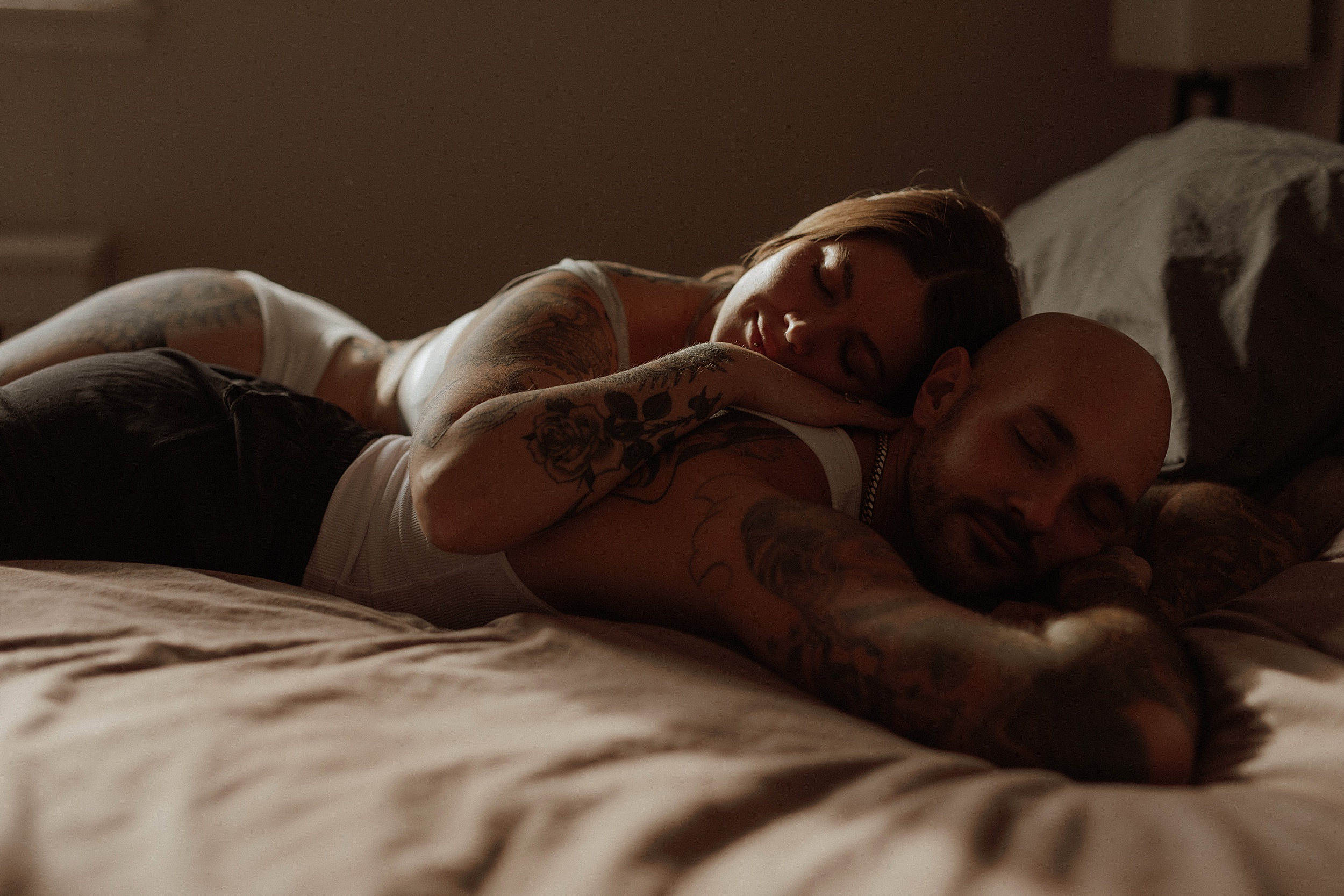 Couple lays stacked on one another during Mary Castillo couples boudoir session