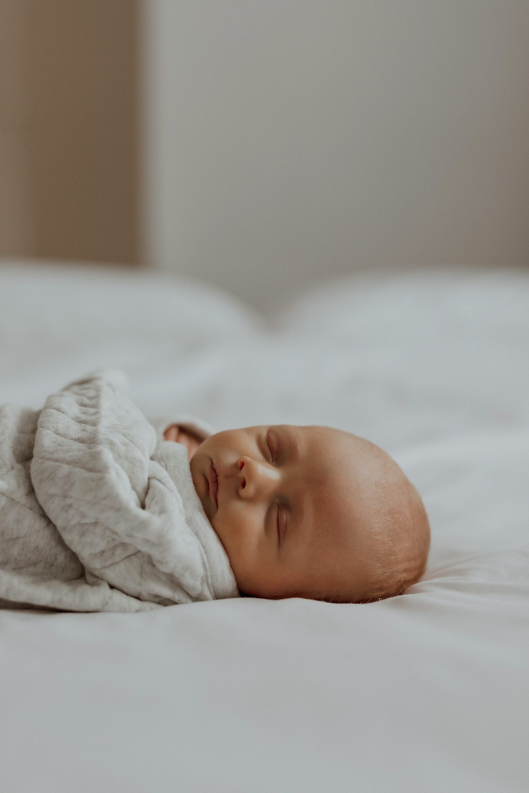 Close up of baby's sleeping face on a bed by Minneapolis Boudoir Photographer