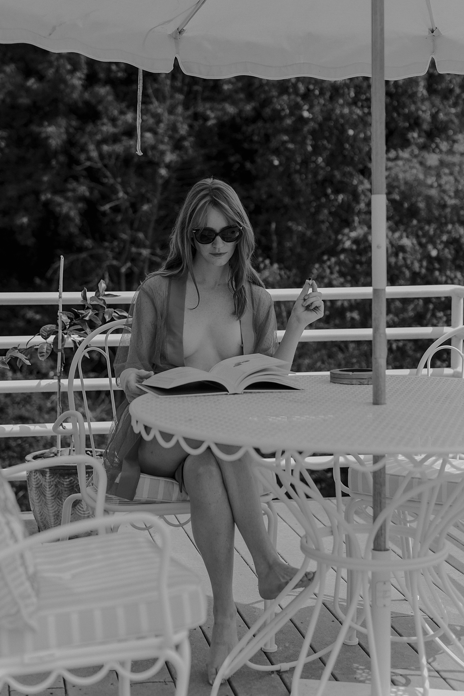 model sits outdoors reading with joint in hand by Mary Castillo Photography