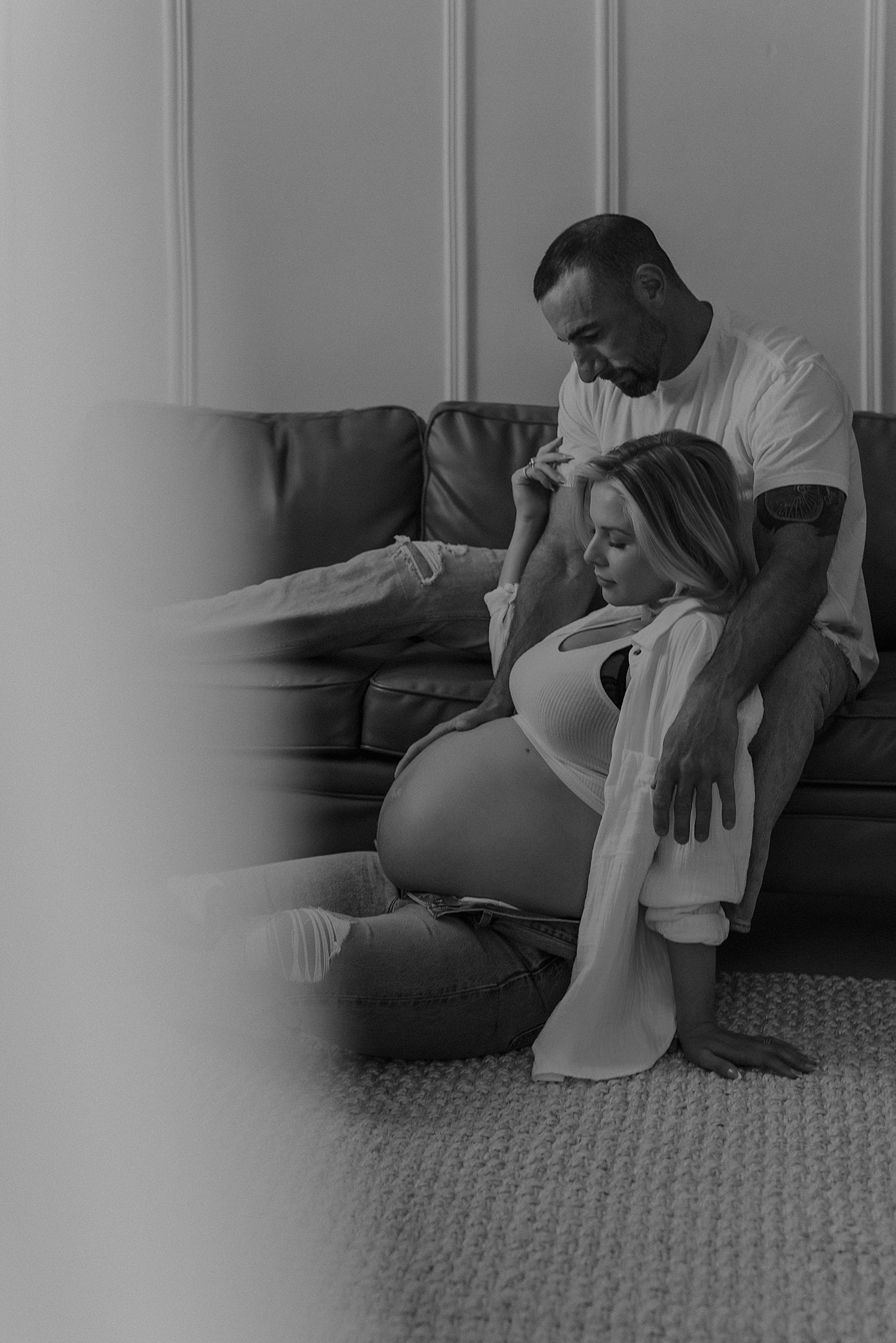 man sits on couch holding pregnant wife by Mary Castillo photography 
