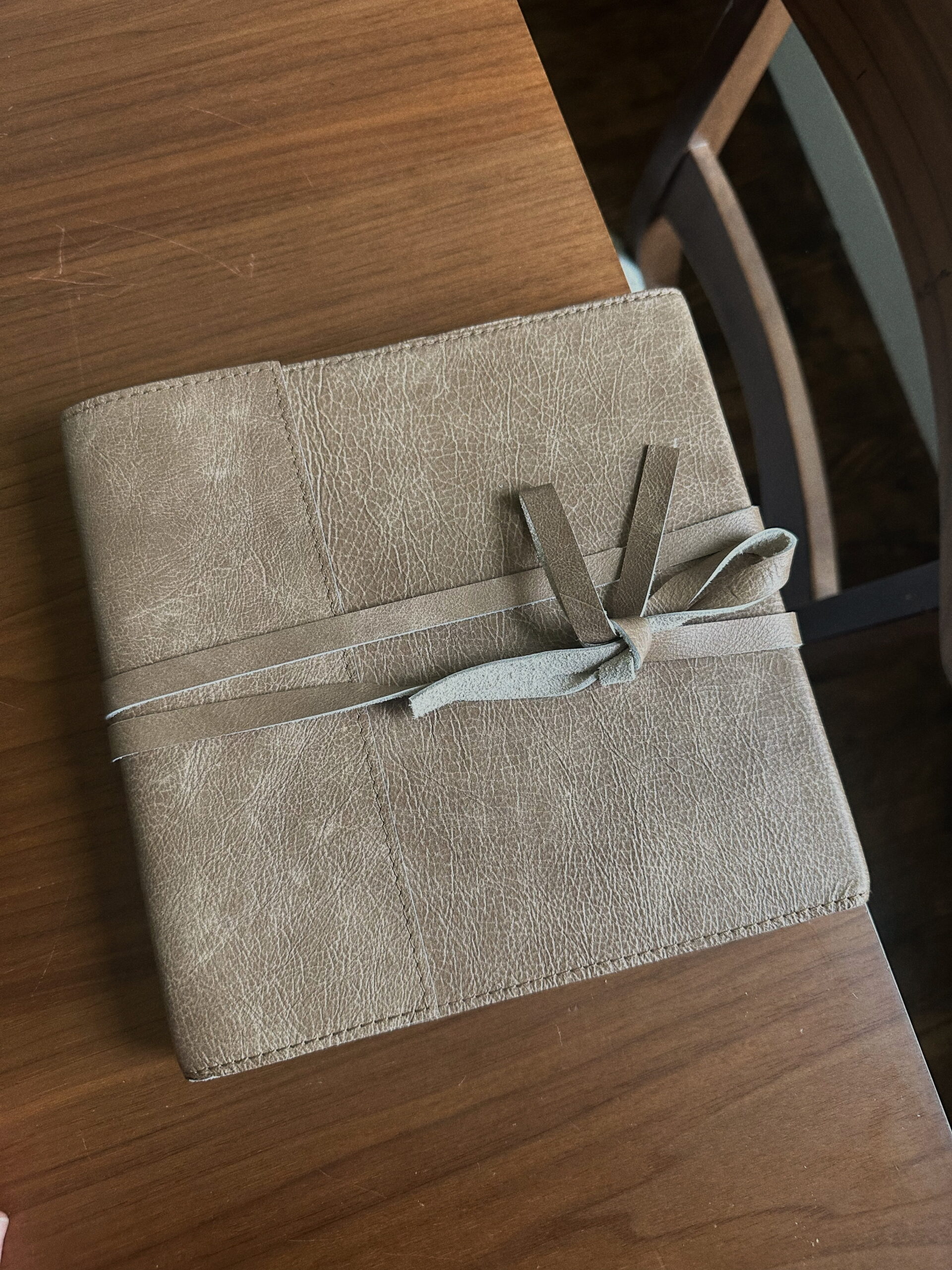 Journal-style album sitting on dining table by Mary Castillo Photography