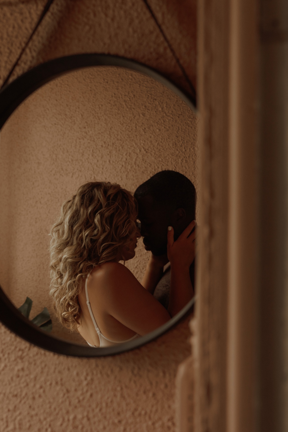 Mirror reflection of young couple sharing an intimate embrace during Steamy Couple's Portraits
