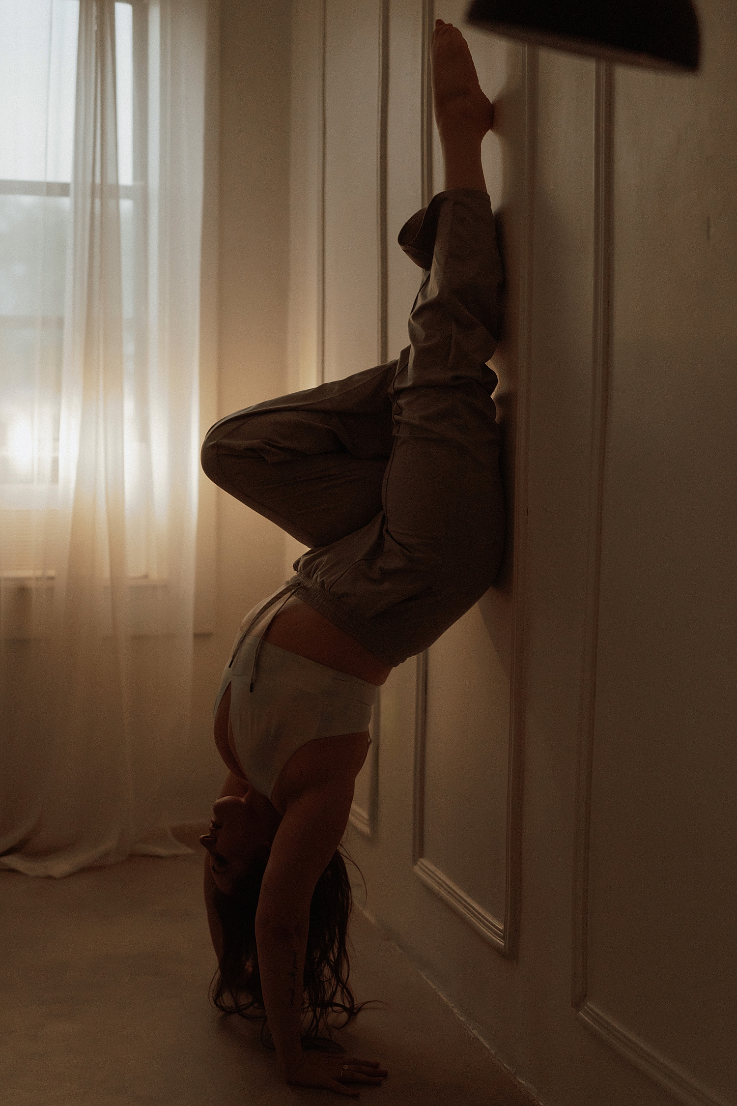 person does a handstand in sweats by Mary Castillo Photography