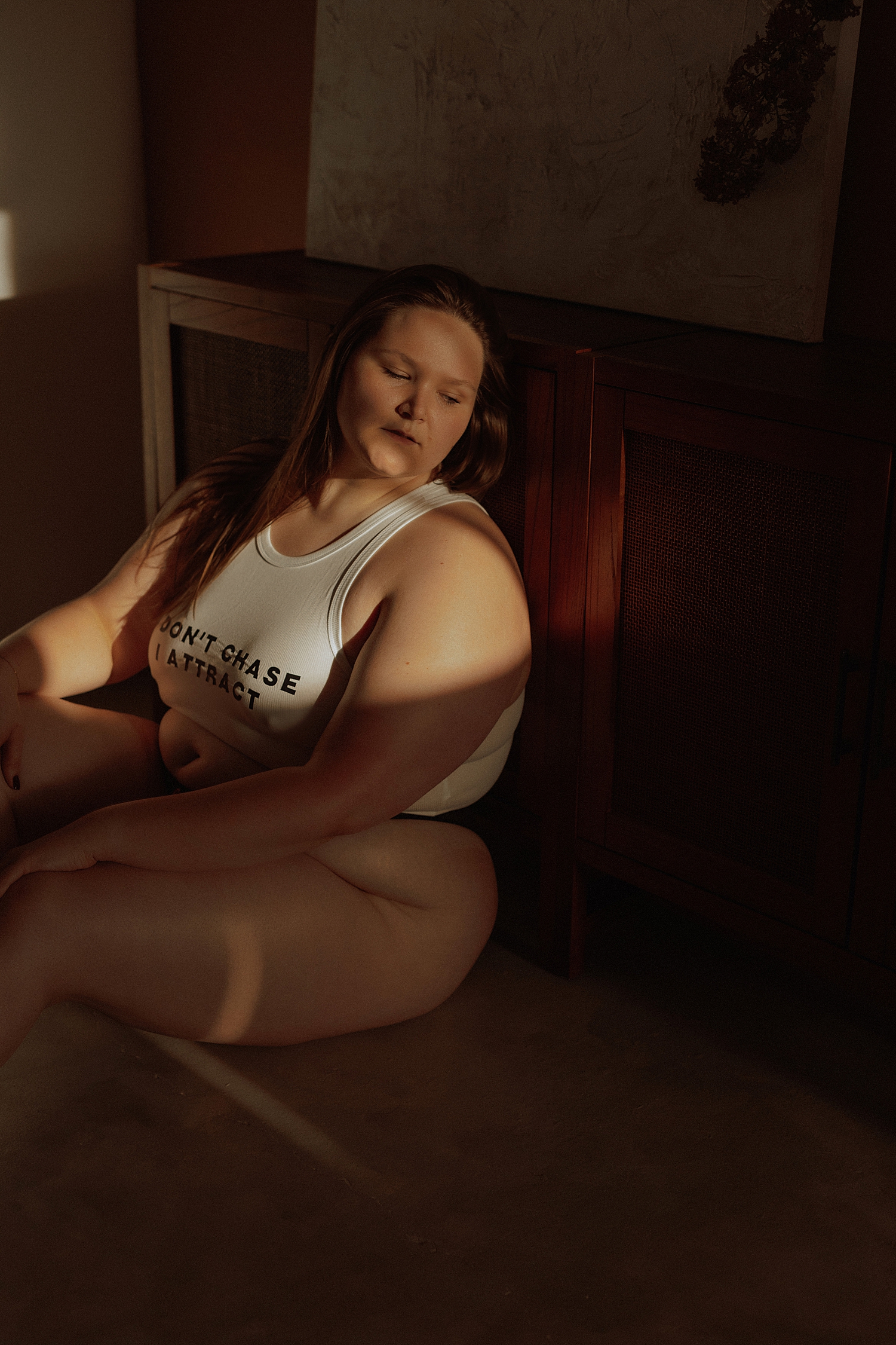 brunette model leans against wooden cabinet by Mary Castillo Photography
