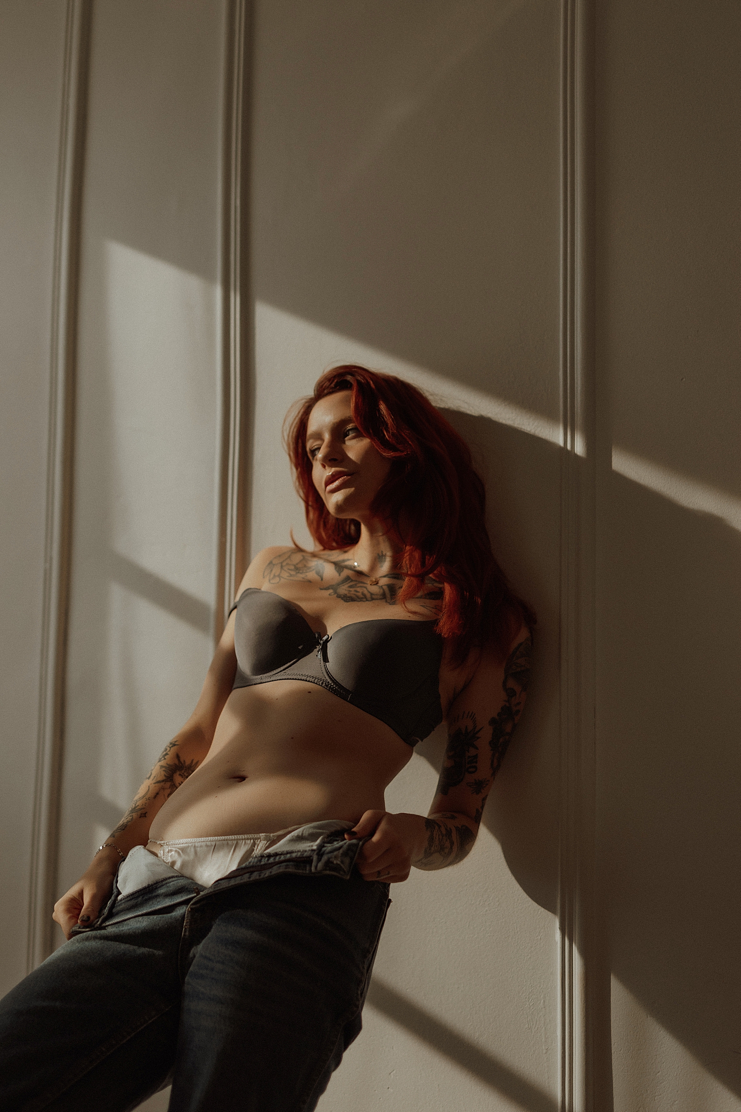 woman in gray bra and denim leans back against wall by Mary Castillo Photography