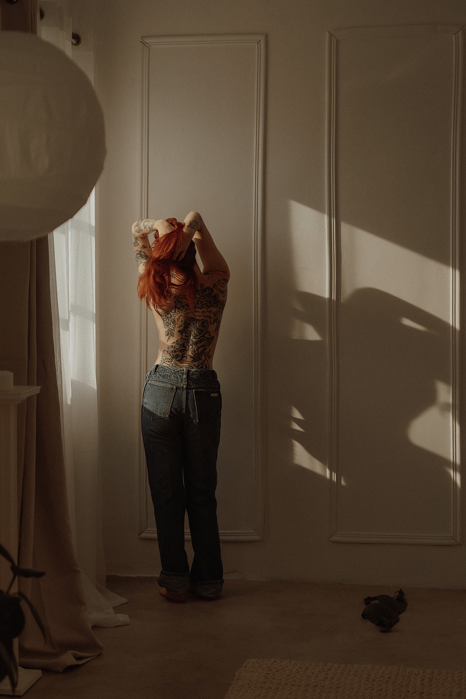redhead with back tattoos stands topless in studio for Golden Hour Model Session