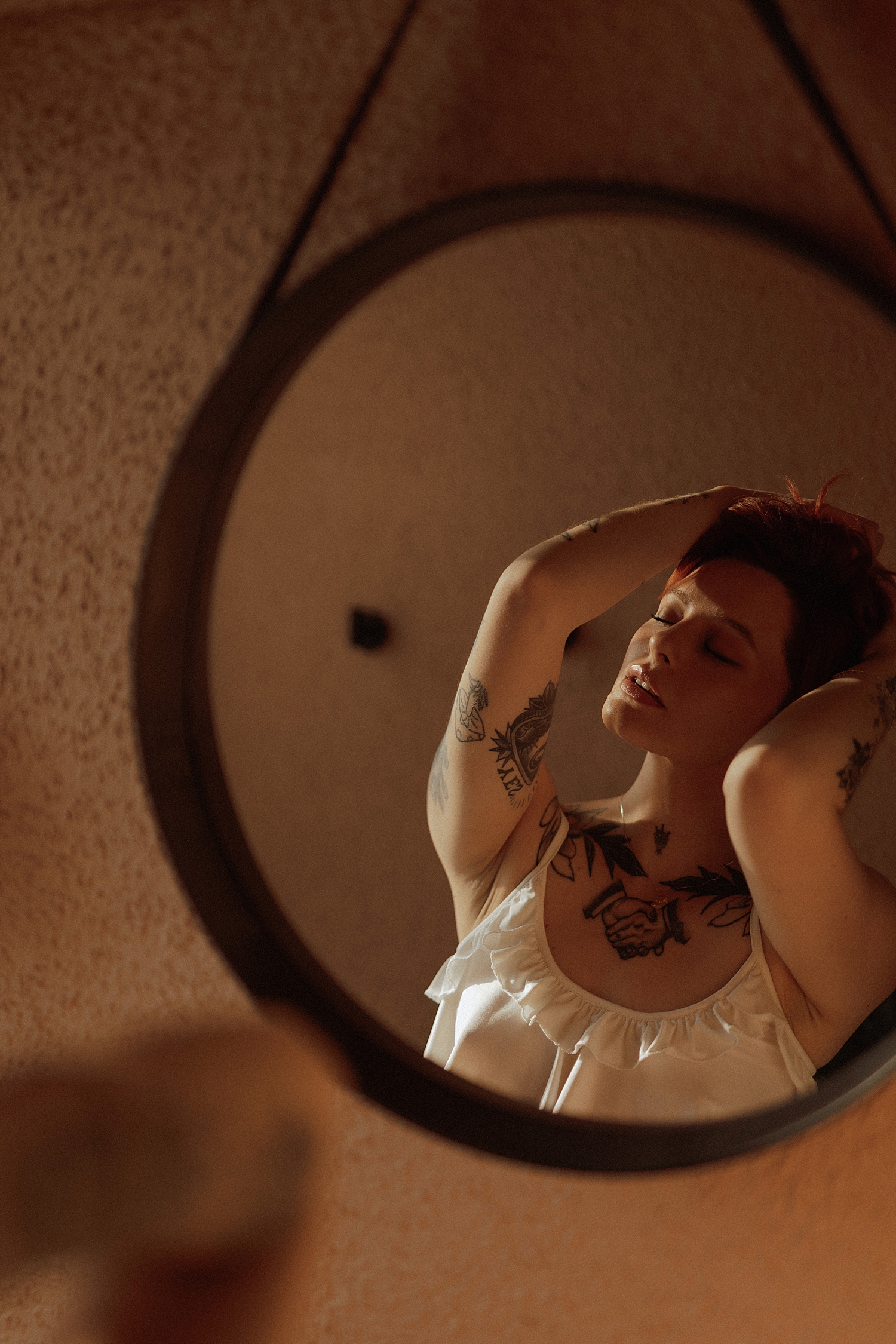woman with tattoos reflection in a circle mirror for Golden Hour Model Session