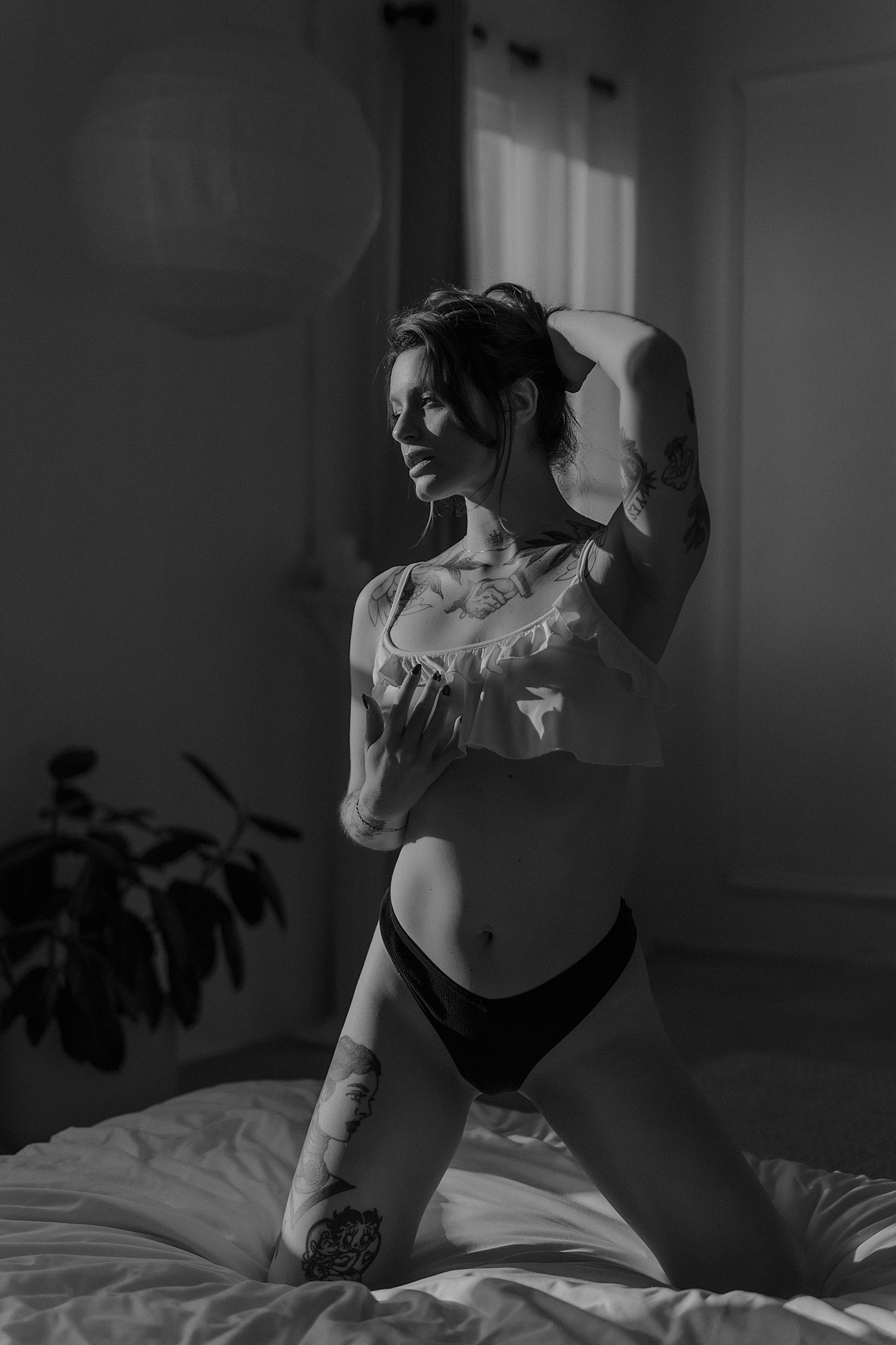 woman kneels on bed in ruffle top and thong for Golden Hour Model Session