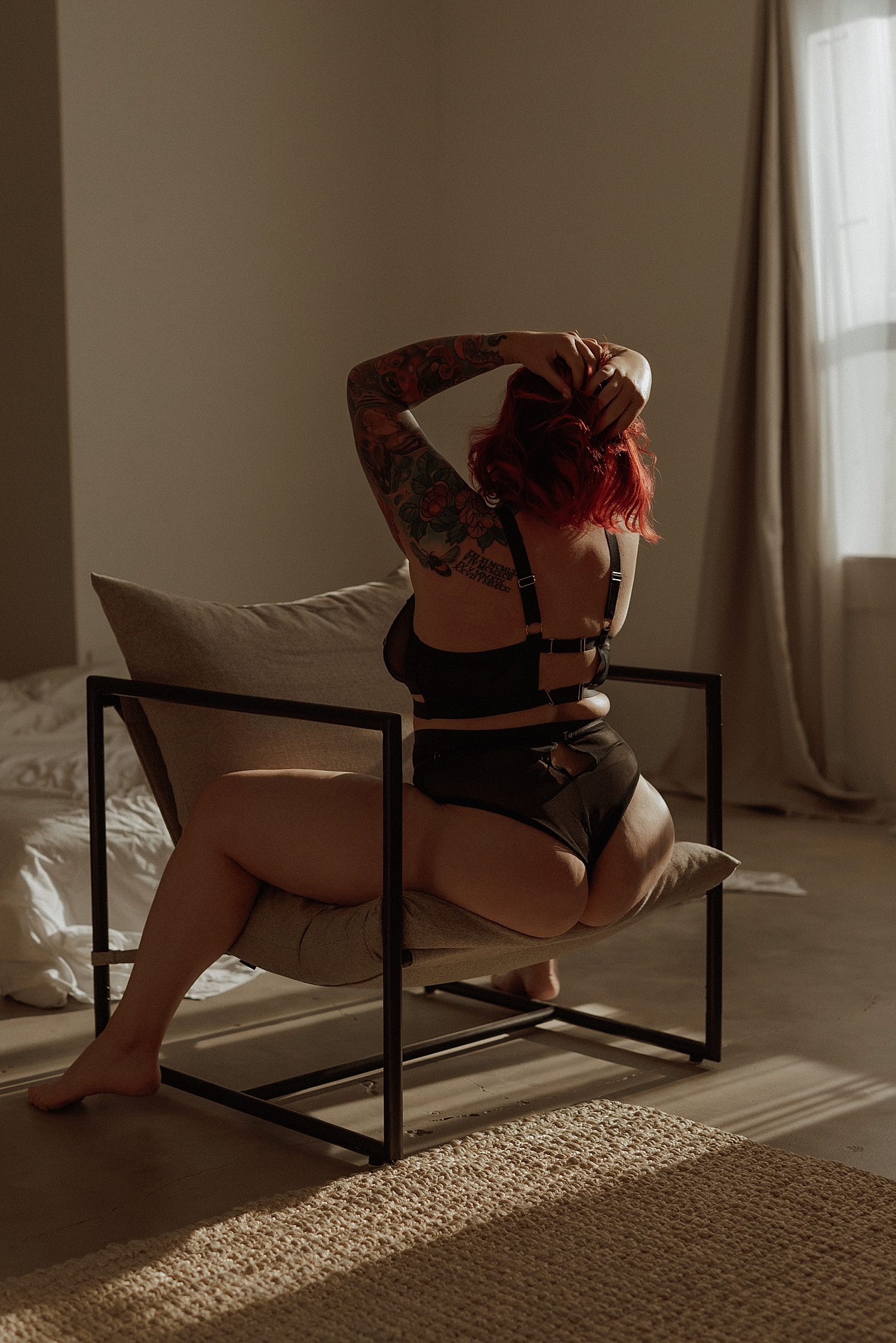 artist in black two piece straddles a chair by Mary Castillo Photography