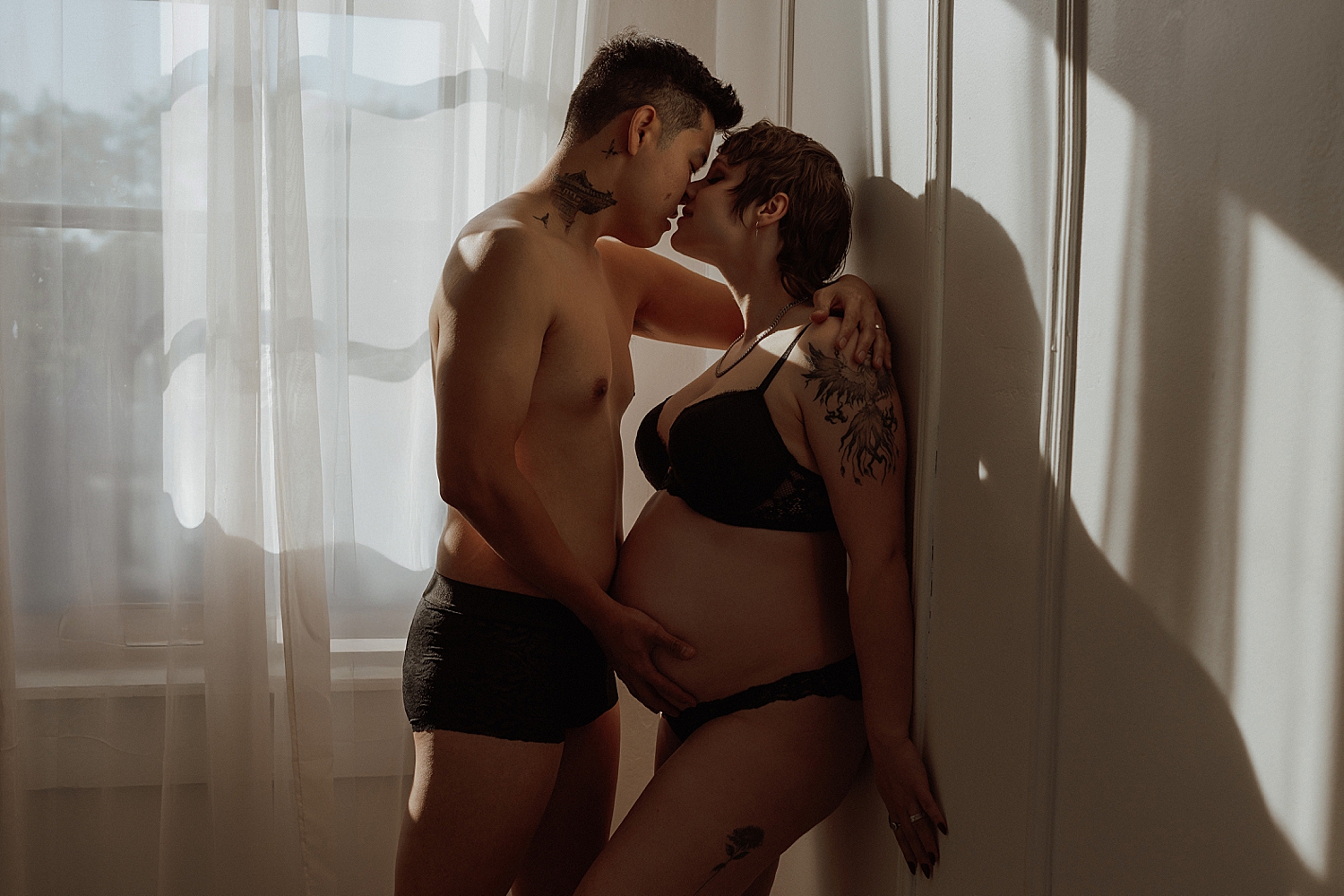 man leans in to hold his wife's pregnant belly by Mary Castillo Photography