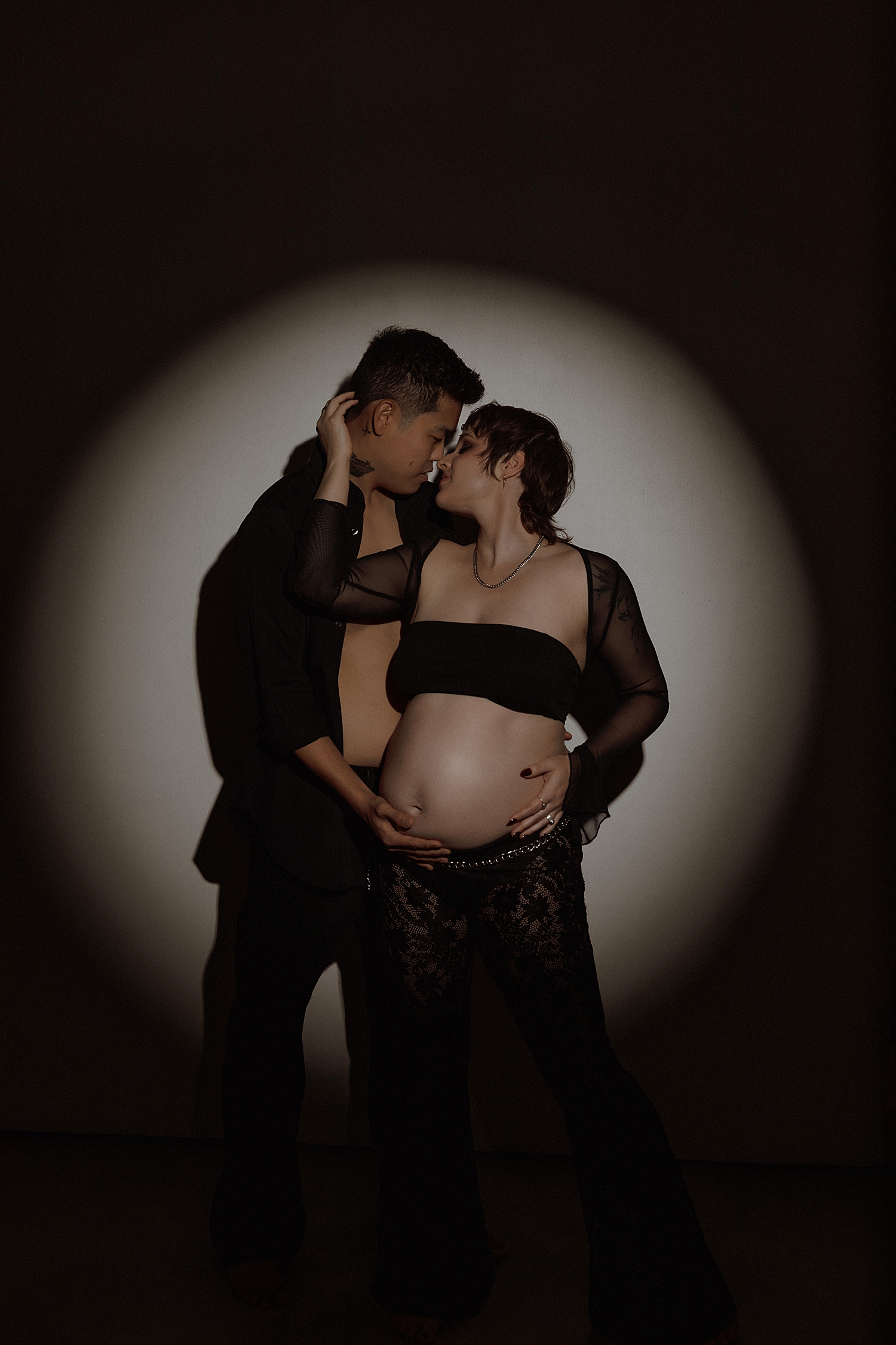 husband and wife embrace under strobe light by Minneapolis boudoir photographer